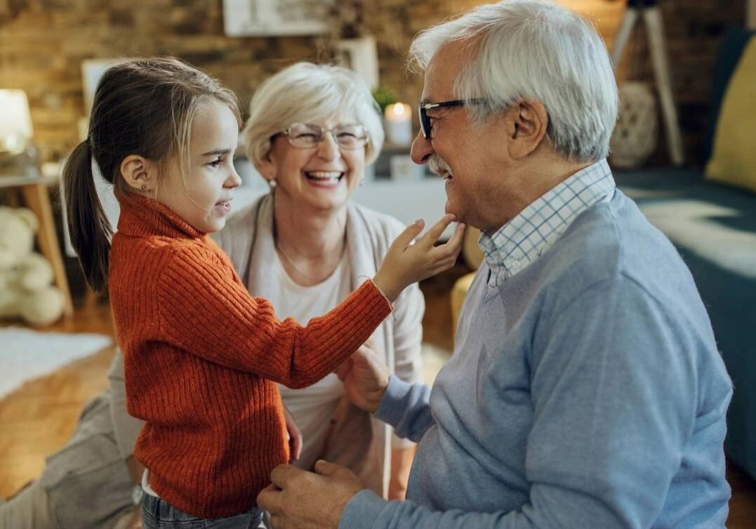 small girl spending time with her grandparents at home